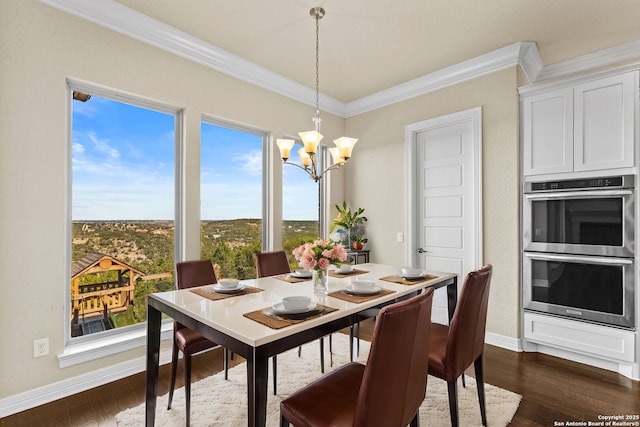 dining area with dark hardwood / wood-style floors, crown molding, and a chandelier