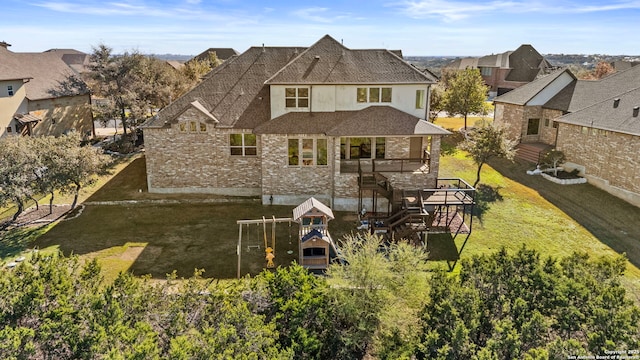 rear view of property with a playground and a lawn