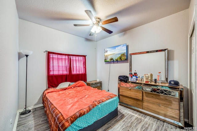 bedroom featuring hardwood / wood-style flooring, ceiling fan, and a textured ceiling