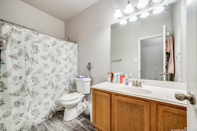 bathroom with vanity, hardwood / wood-style flooring, toilet, and walk in shower