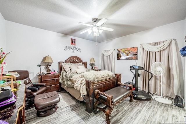 bedroom featuring ceiling fan, a textured ceiling, and hardwood / wood-style flooring