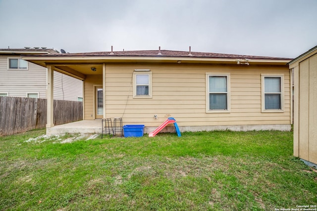 rear view of property featuring a lawn and a patio area