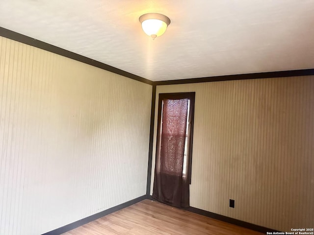 empty room featuring crown molding and hardwood / wood-style flooring