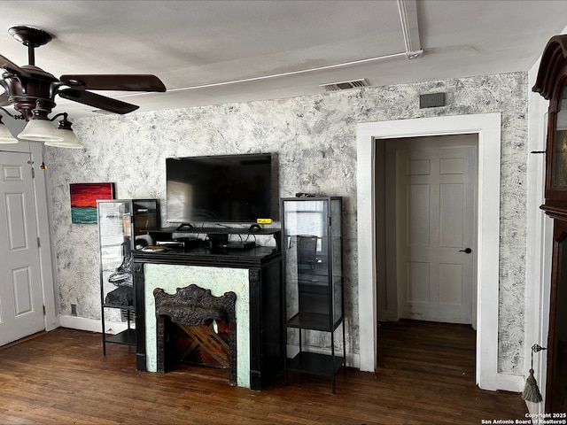 living room featuring a high end fireplace, ceiling fan, and dark wood-type flooring