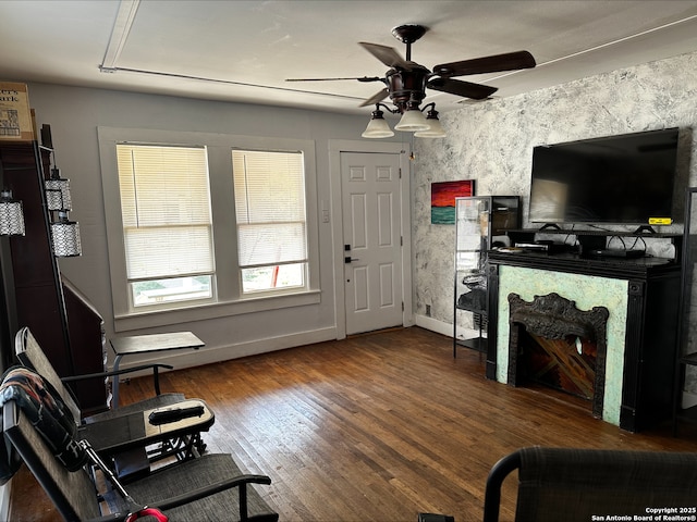 living room featuring hardwood / wood-style flooring, ceiling fan, and a premium fireplace