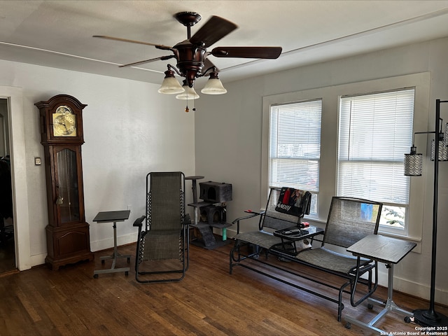 living area with ceiling fan and dark hardwood / wood-style floors