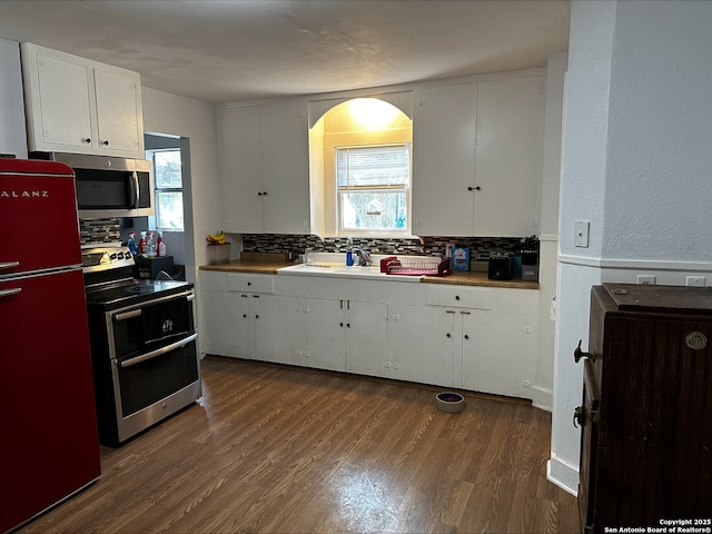 kitchen with dark hardwood / wood-style floors, a healthy amount of sunlight, white cabinetry, and stainless steel appliances