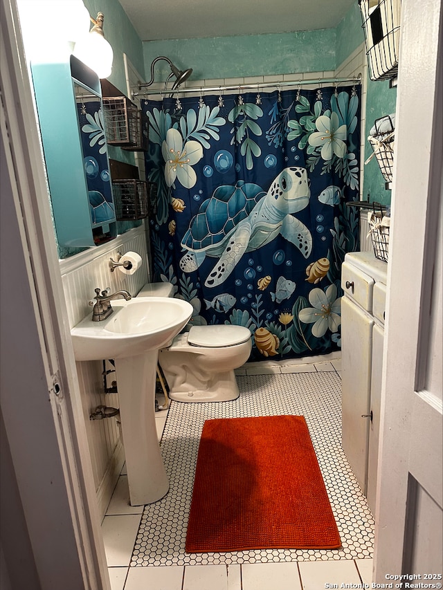 bathroom with tile patterned flooring, toilet, and sink