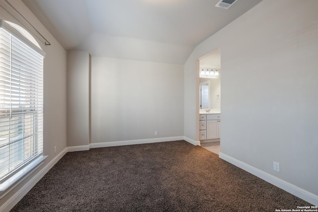 carpeted empty room featuring lofted ceiling