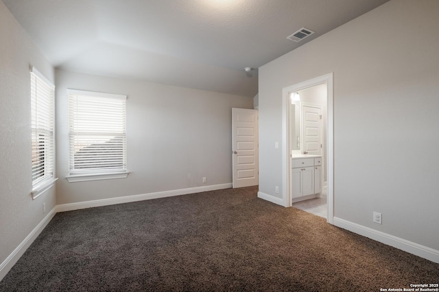 unfurnished bedroom featuring carpet floors and connected bathroom