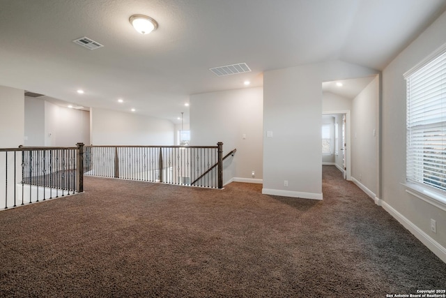 empty room with carpet flooring and vaulted ceiling