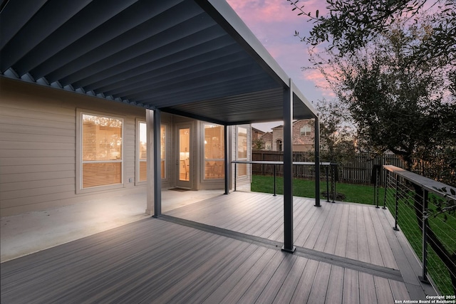 deck at dusk featuring a yard