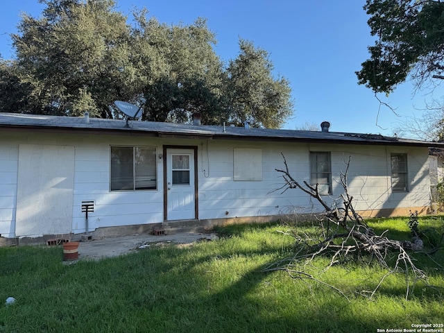 rear view of property featuring a yard