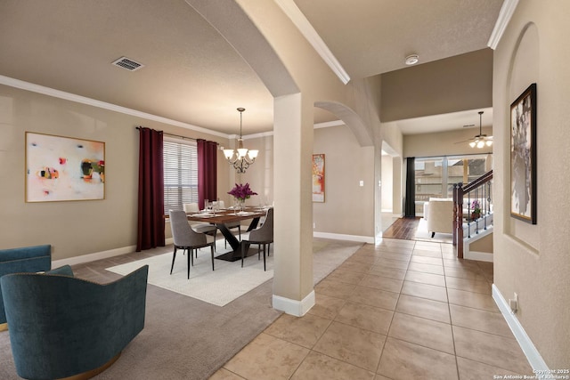 dining room with crown molding, a wealth of natural light, ceiling fan with notable chandelier, and light tile patterned floors