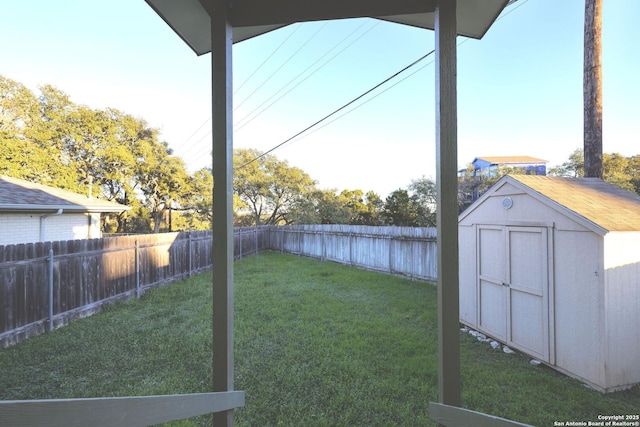 view of yard with a storage unit, an outdoor structure, and a fenced backyard