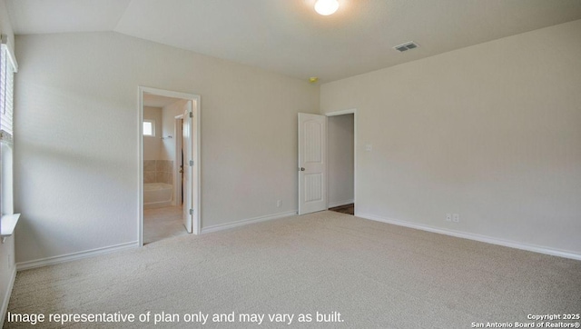 unfurnished bedroom with light carpet, ensuite bath, and lofted ceiling