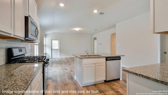 kitchen with light stone counters, sink, white cabinets, and appliances with stainless steel finishes