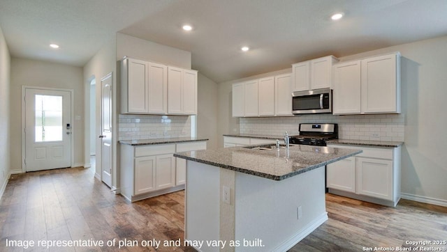 kitchen with white cabinets, a center island with sink, and appliances with stainless steel finishes