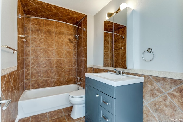 full bathroom with tiled shower / bath combo, tile patterned floors, toilet, vanity, and tile walls