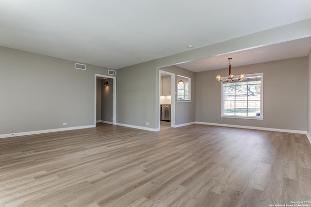 unfurnished room with light wood-type flooring and a chandelier