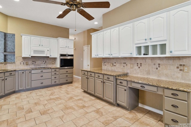 kitchen featuring gray cabinetry, white cabinetry, oven, and light stone countertops