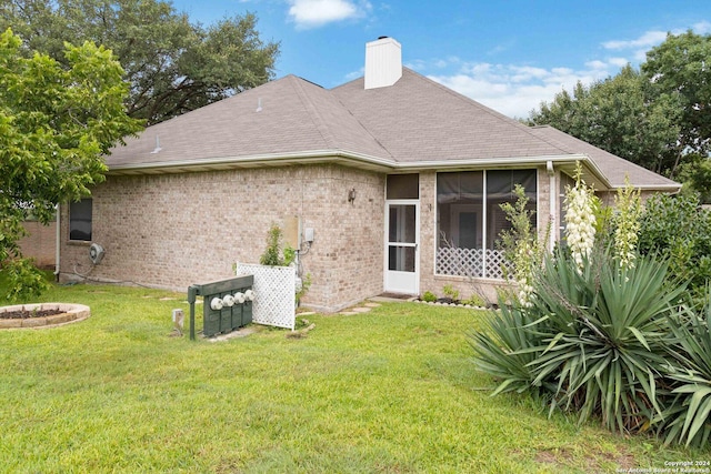 back of house with a sunroom and a yard