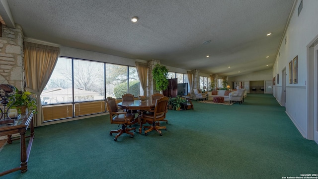 carpeted dining area featuring plenty of natural light, lofted ceiling, and a textured ceiling