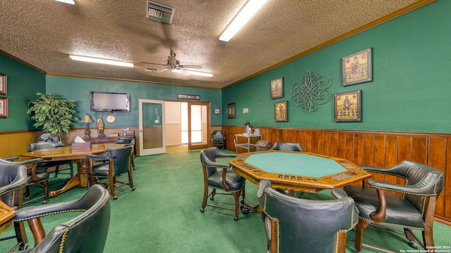 game room with ceiling fan, ornamental molding, a textured ceiling, and carpet floors