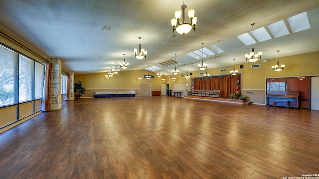 miscellaneous room with dark hardwood / wood-style flooring and vaulted ceiling with skylight