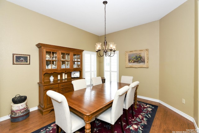 dining room featuring dark hardwood / wood-style flooring and a notable chandelier