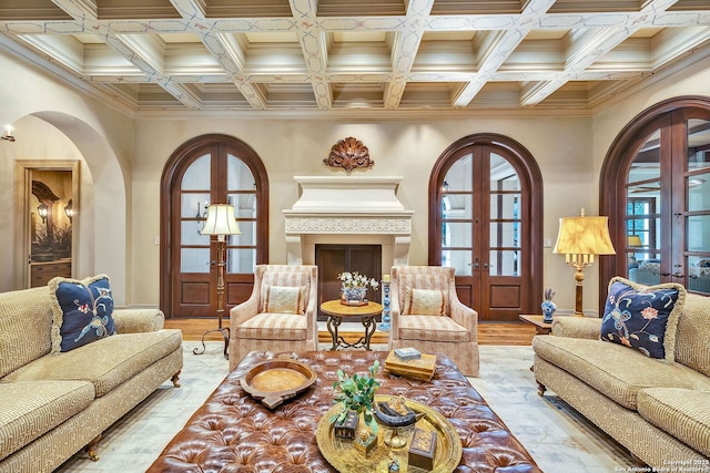 living room with arched walkways, beamed ceiling, wood finished floors, and french doors