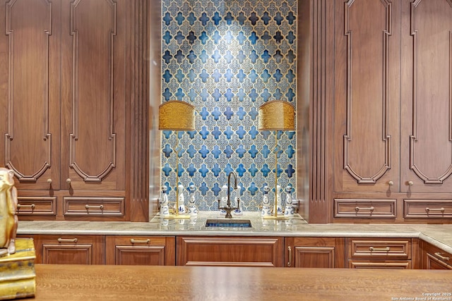 kitchen featuring light countertops, brown cabinets, and a sink