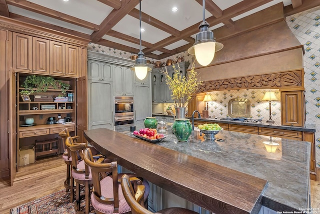 kitchen featuring light wood finished floors, decorative backsplash, coffered ceiling, and beam ceiling