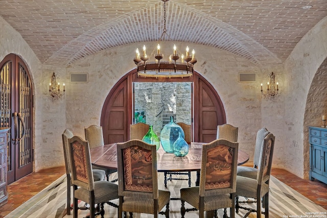 dining area with brick ceiling, visible vents, a notable chandelier, and arched walkways