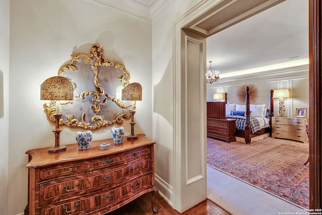 hall with ornamental molding and a chandelier