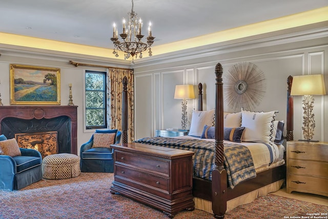 carpeted bedroom with a fireplace, a decorative wall, and an inviting chandelier