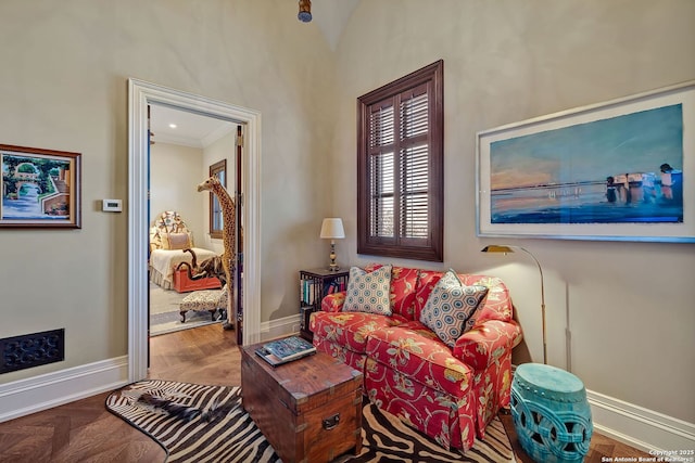 living area with baseboards and ornamental molding