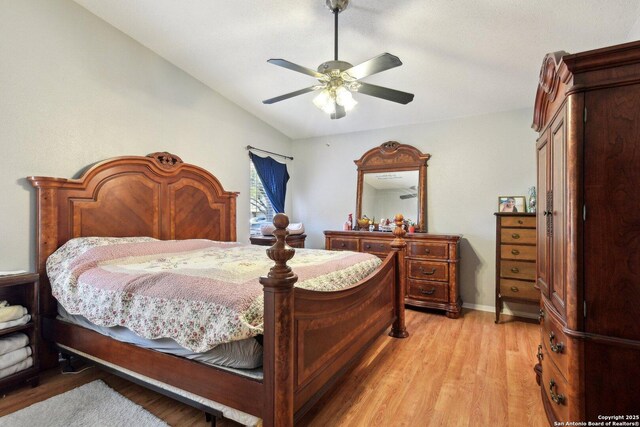 bedroom with ceiling fan, light hardwood / wood-style floors, and lofted ceiling