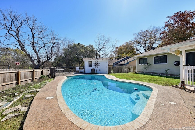 view of swimming pool featuring an outbuilding and a yard