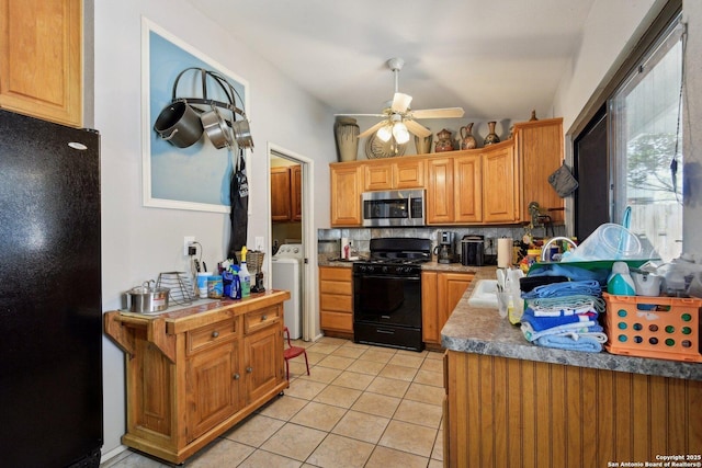 kitchen with black appliances, ceiling fan, tasteful backsplash, light tile patterned flooring, and washing machine and clothes dryer