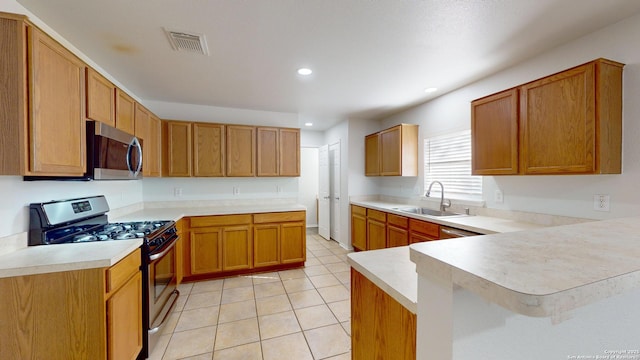 kitchen featuring sink, kitchen peninsula, stainless steel appliances, and light tile patterned floors