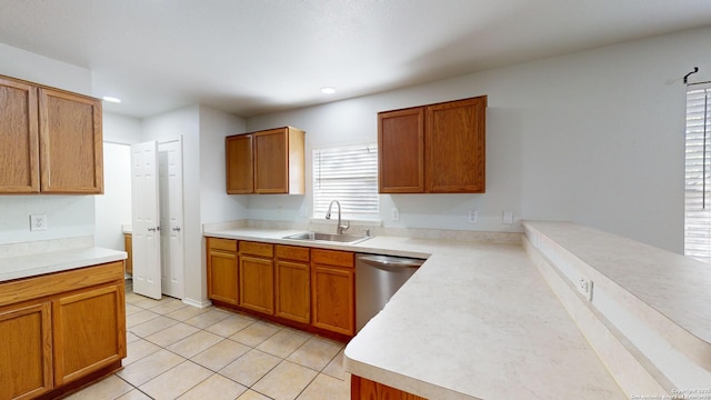 kitchen featuring dishwasher, light tile patterned flooring, and sink