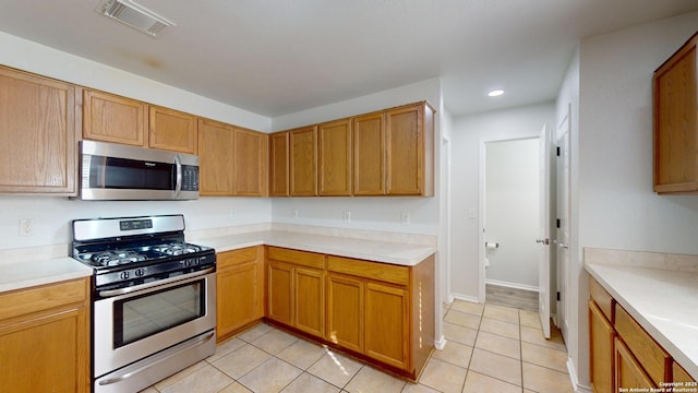 kitchen with light tile patterned flooring and appliances with stainless steel finishes