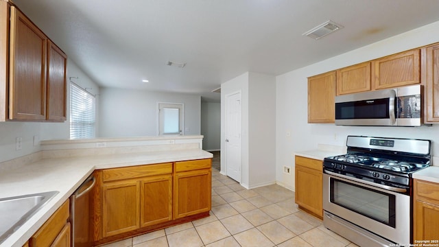 kitchen featuring kitchen peninsula, light tile patterned floors, sink, and appliances with stainless steel finishes