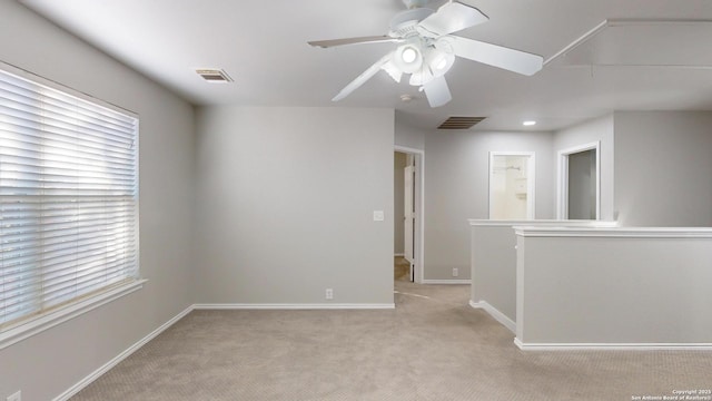 spare room with ceiling fan and light colored carpet