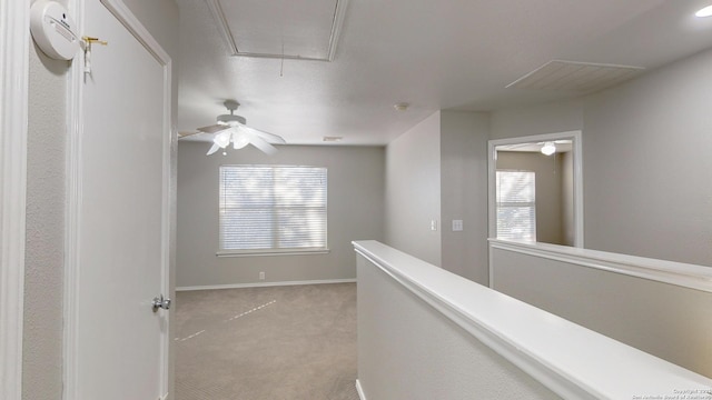 hall with light colored carpet