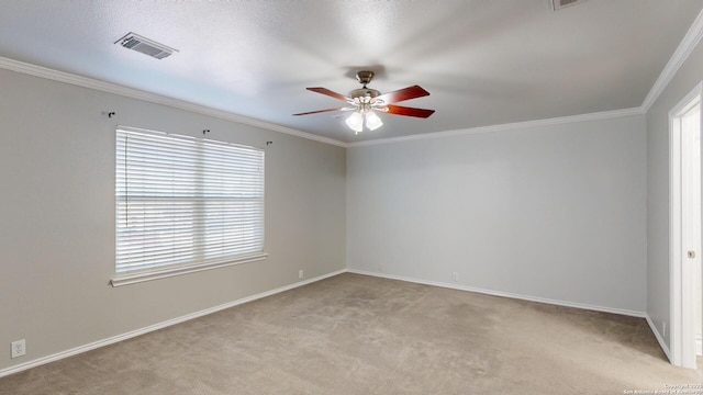 spare room with ceiling fan, light colored carpet, and crown molding