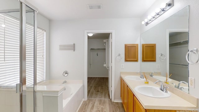 bathroom featuring hardwood / wood-style flooring, vanity, a bath, and a wealth of natural light