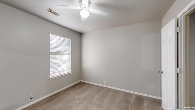 carpeted spare room featuring ceiling fan