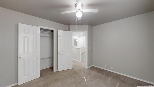 unfurnished bedroom featuring ceiling fan, a closet, and light colored carpet